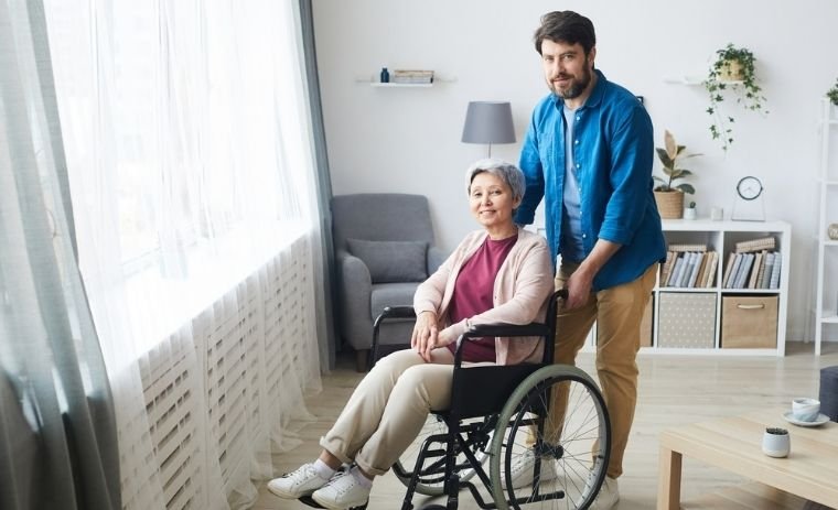 A family caregiver assisting a senior woman in a wheelchair at home, representing the Michigan Home Care Program and quality senior care support
