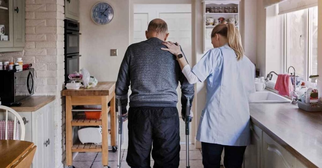 Caregiver assisting a senior using a walker at home, demonstrating adaptive home modifications for seniors to improve safety and mobility.