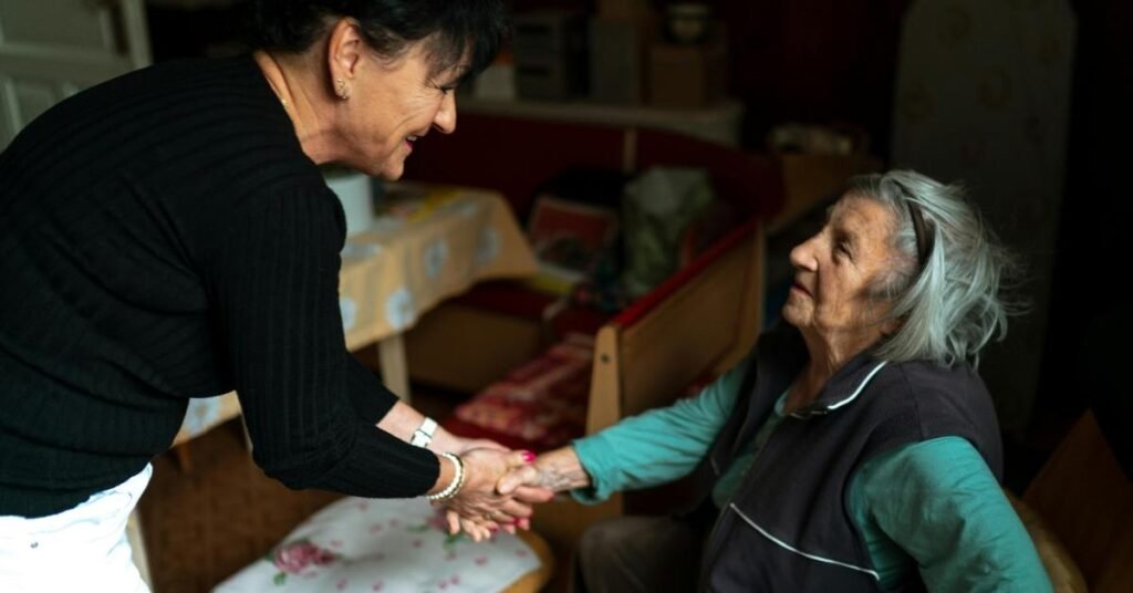 Caregiver providing compassionate in-home support to an elderly woman, illustrating managing chronic illness at home with daily assistance and emotional care.