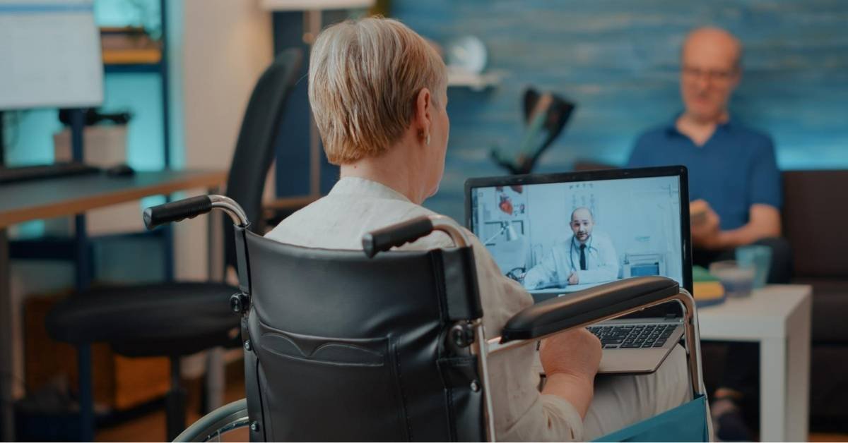 Senior receiving telehealth consultation at home through video call as part of telehealth and remote monitoring supported home care in Michigan.